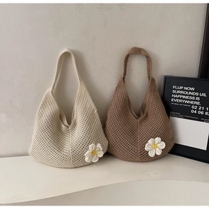 Detail of hand-knitted hobo tote bag featuring large hollow weave and 3D daisy flower