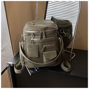 Detail of olive green multi-pocket backpack with matte fabric and silver hardware buckles