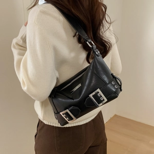 Detail showing high-quality black faux leather texture and silver buckle accents of the bag