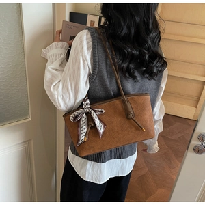 Détail du sac cabas caramel avec texture tissée en losange et foulard décoratif