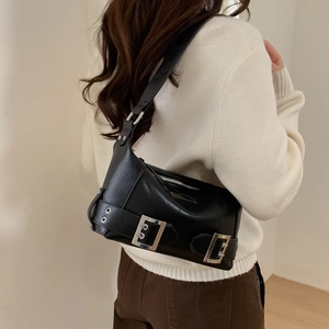 Detail of black faux leather underarm bag featuring three vintage silver metal buckles