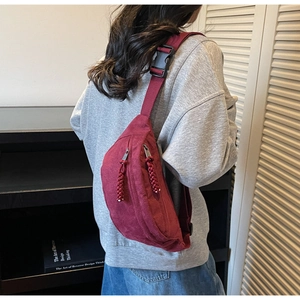 Vue détaillée d'un sac bandoulière bordeaux avec double fermeture et tirettes tissées