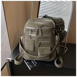 Detail of army green travel backpack featuring multiple pockets and durable matte fabric