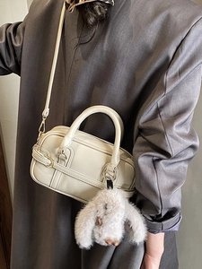 Creamy white retro boston bag with plush bunny pendant and adjustable shoulder strap