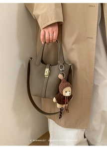 Détail du sac seau en cuir grainé avec pendentif ours et boucle en métal dorée