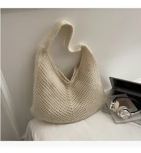 Close-up of cream knit tote bag with V-shaped hollow crochet texture and Hobo style