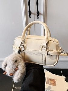 Minimalist cream white leather Boston bag with plush rabbit charm and crossbody strap