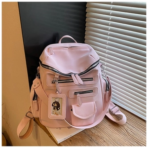 Detailed side view of pink multi-pocket travel backpack on window sill with natural light