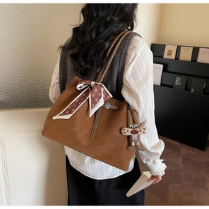 Brown faux suede tote bag featuring a decorative silk scarf and plush rabbit charm detail