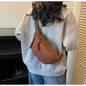 Détail du sac croissant en velours côtelé marron avec gland tissé et sangle large