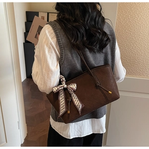 Sac cabas tissé marron foncé avec foulard en soie et bandoulière nouée sur le mannequin