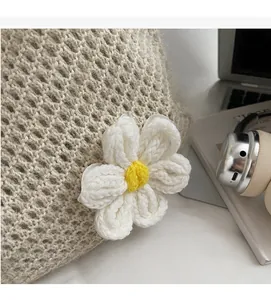 Detail of crochet knit tote bag featuring a 3D white daisy flower and mesh texture