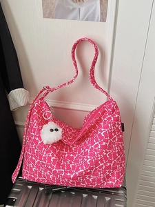 Sac fourre-tout en toile à fleurs roses avec charme monstre sur une valise
