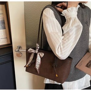Détail d'un sac cabas tissé vintage marron foncé avec foulard décoratif en soie