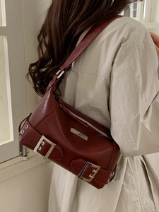 Vintage burgundy leather underarm bag with silver buckle details and retro punk style