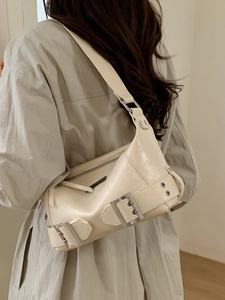 Chic cream-colored underarm bag with glossy leather and biker-style silver buckles