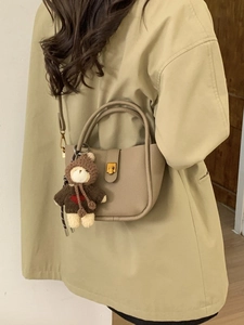 Retro bucket crossbody bag in beige leather with cute bear charm and golden buckle detail