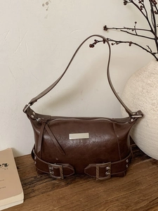 Retro brown faux leather underarm bag with metal accents and sleek pillow shape