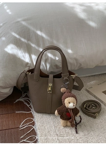 Sac seau rétro en cuir marron grainé avec fermoir doré et accessoire de charme d'ours