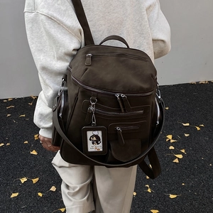 Detail of olive green vintage backpack with multiple utility pockets and textured fabric