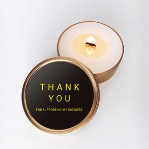 Scented candle in gold tin with Thank You message and natural wood wick on white background
