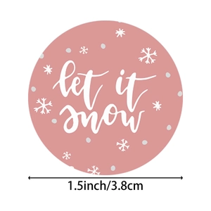 1.5 inch pink Christmas sticker featuring let it snow text and white snowflake patterns