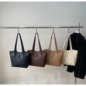 Detailed display of four textured faux leather tote bags in various neutral colors