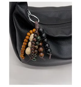 Detail of vintage beaded charms with wood texture and silver metal rings for shoulder bags