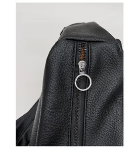 Detailed close-up of premium black pebble grain leather and smooth silver metal zipper