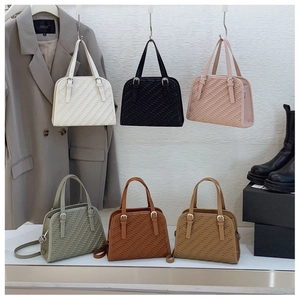Detalle de bolsos de hombro cuadrados en seis colores con textura tejida y asas superiores
