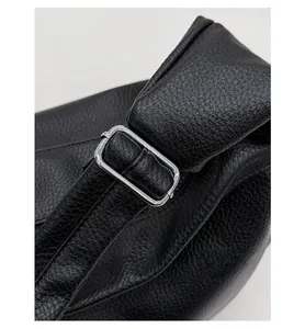 Detail of premium silver metal buckle and black litchi pattern leather shoulder strap