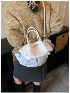 Détail du sac à main blanc plissé avec boucle en métal doré et pendentif lapin en peluche