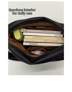Spacious interior of a black leather tote with books, umbrella and functional pockets
