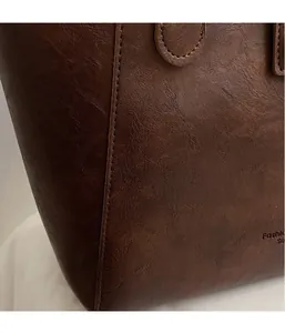 Close-up of vintage brown tote bag showing lychee leather texture and stitching