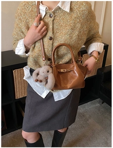 Détail du sac à main plissé marron avec fermoir métallique et breloque lapin en peluche