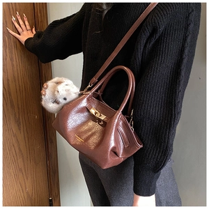 Détail d'un sac à main plissé en similicuir marron avec fermoir rotatif doré