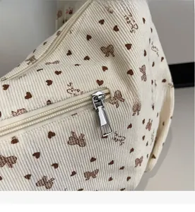 Nahaufnahme eines glatten Silbermetall-Reißverschlusses an einer beigen Kord-Tasche
