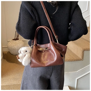 Détail du sac à main en cuir plissé marron avec fermoir en métal et breloque lapin