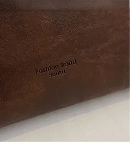 Close-up of litchi texture brown leather tote bag with embossed fashion trend logo