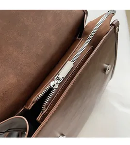 Detailed macro view of silver smooth metal zipper and magnetic buckle on leather bag