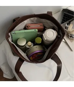 Top view of large brown tote bag showing spacious compartments with daily essentials