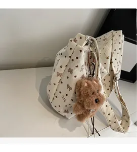 Details der beigen Cordtasche mit braunem Herzprint und Plüsch-Hundeanhänger