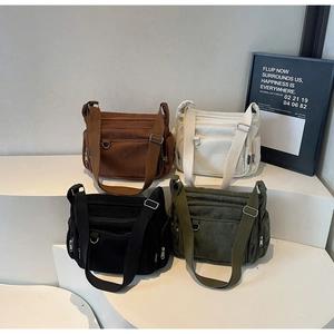Close-up of four-color corduroy crossbody bags with multi-pocket design on display stand