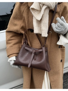 Detailed view of a dark brown vintage tote bag paired with a stylish warm winter outfit