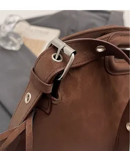 Gros plan de la boucle métallique argentée et de la sangle d'un sac vintage marron