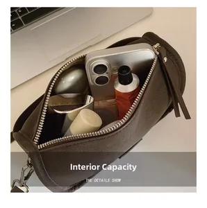 Internal view of brown cylinder bag showing phone, lipstick, and makeup essentials