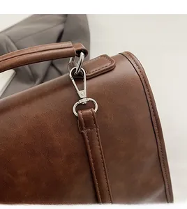 Detail of dark brown leather backpack showing durable metal hook and detachable strap