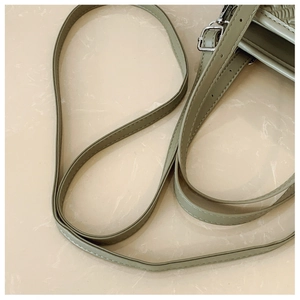 Detalle del bolso de cuero verde salvia con correa ajustable y hebilla de metal