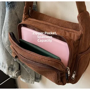 Close-up of brown corduroy tote bag showing large capacity for laptop and zipper details