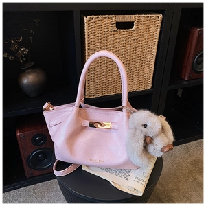 Détail du sac à main plissé en cuir rose avec fermoir doré et breloque lapin